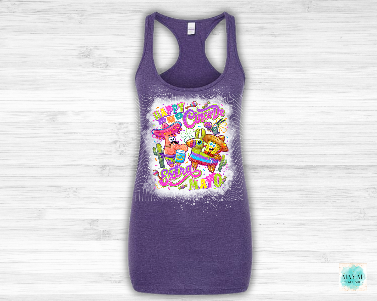 Purple tank top with colorful graphic design on a light wooden background