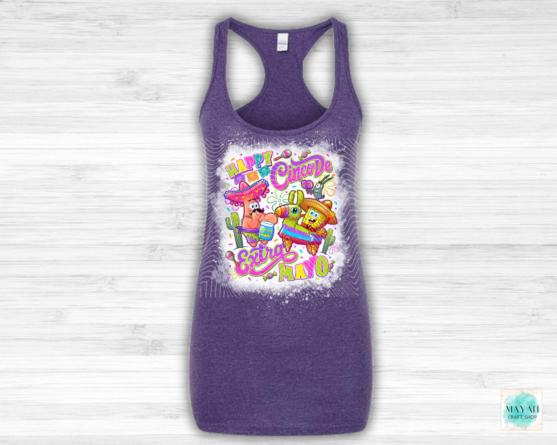 Purple tank top with colorful graphic design on a light wooden background