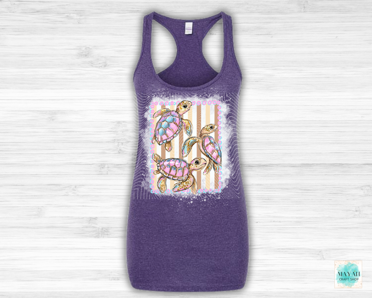 Purple tank top with a colorful turtle design on a light wooden background