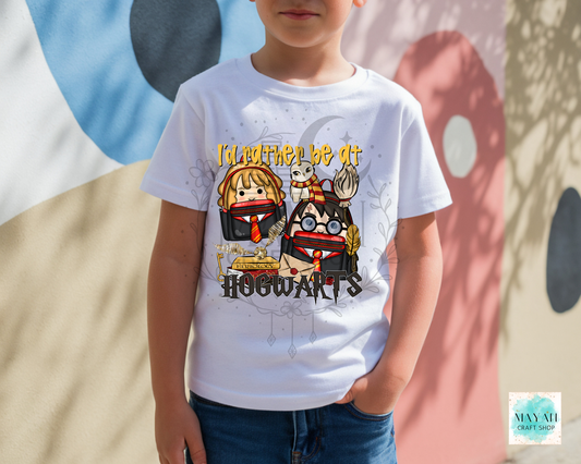 A child wearing a white graphic t-shirt with a cartoon design, standing outdoors against a painted wall.