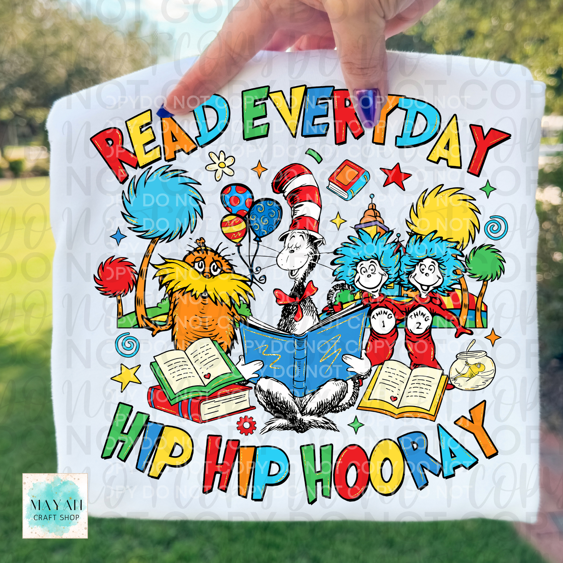 Colorful towel with characters and text Read Everyday text held by a hand outdoors.