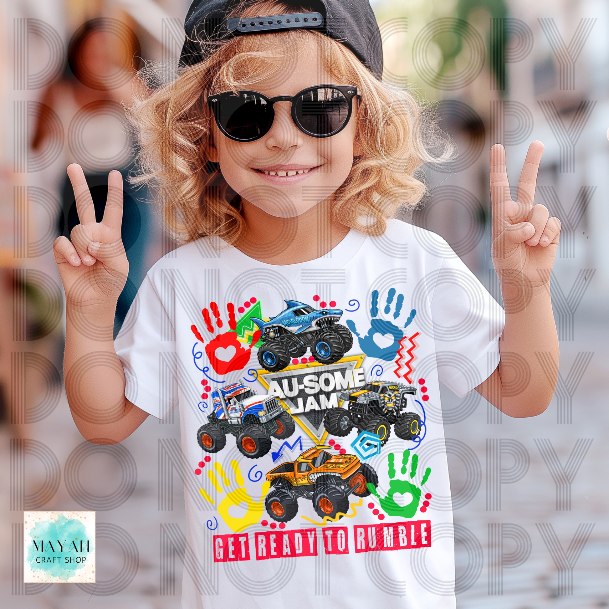 Child wearing a white t-shirt with colorful monster truck design and peace signs.