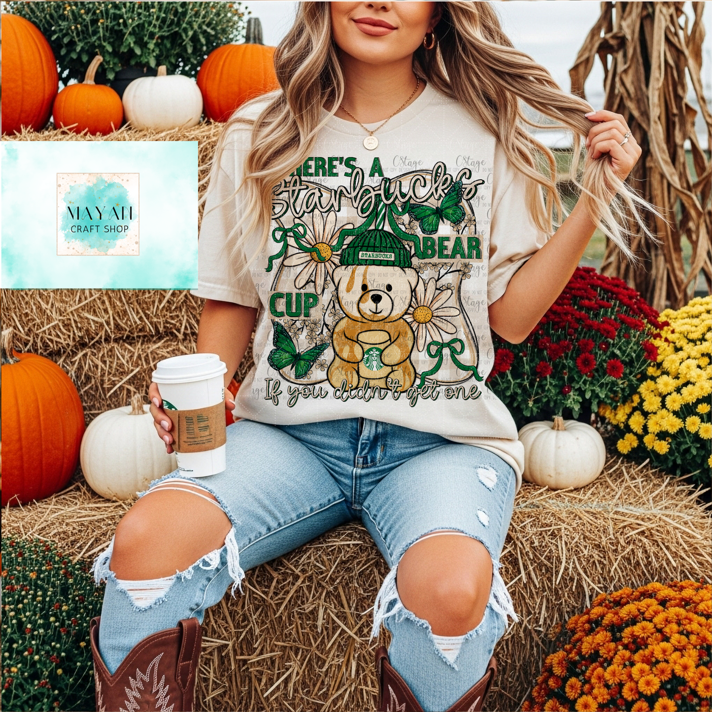 Person wearing a t-shirt with a bear graphic and text, sitting on hay bales with pumpkins and flowers.