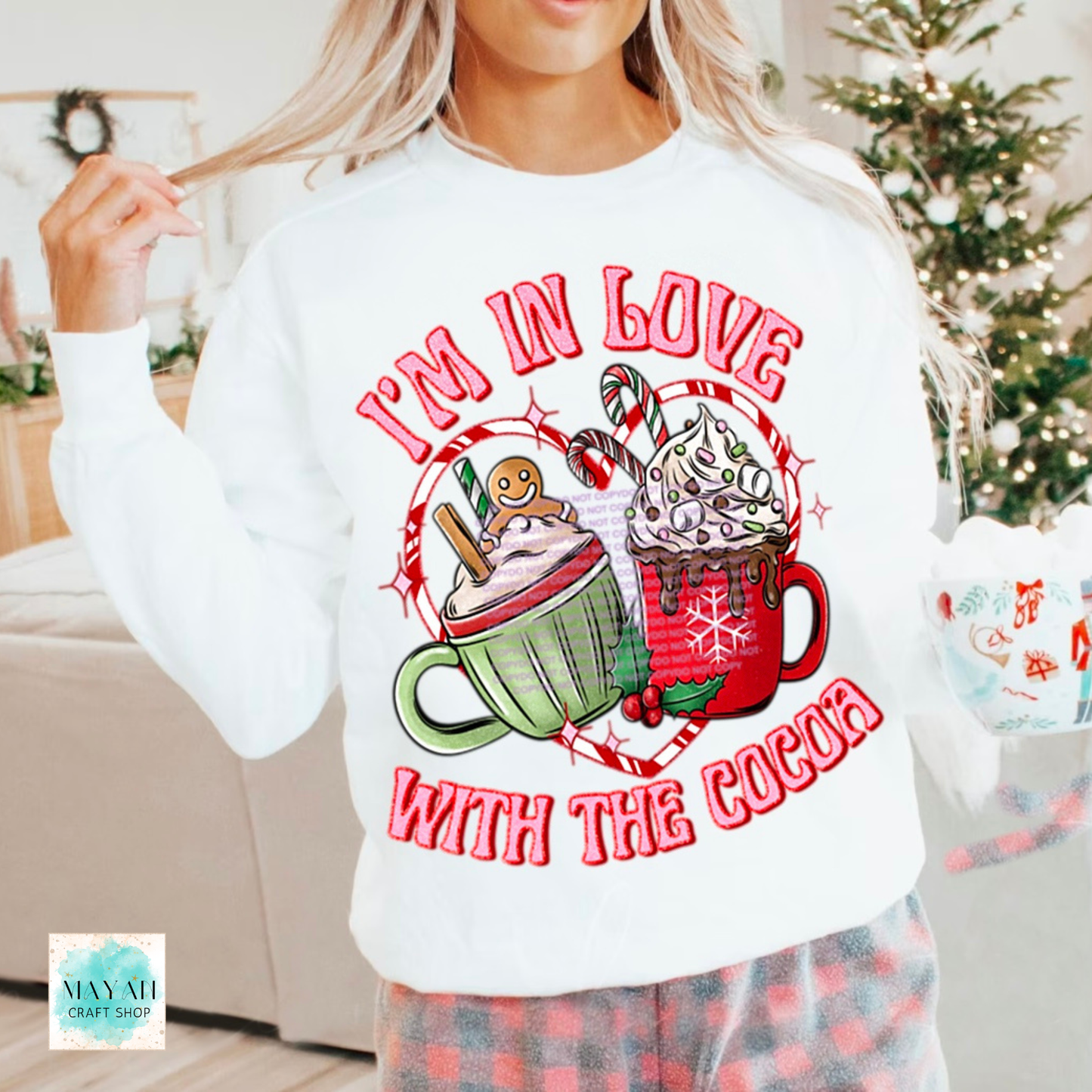Person wearing a white sweatshirt with Christmas-themed design and text 'I'm in love with the cocoa'.