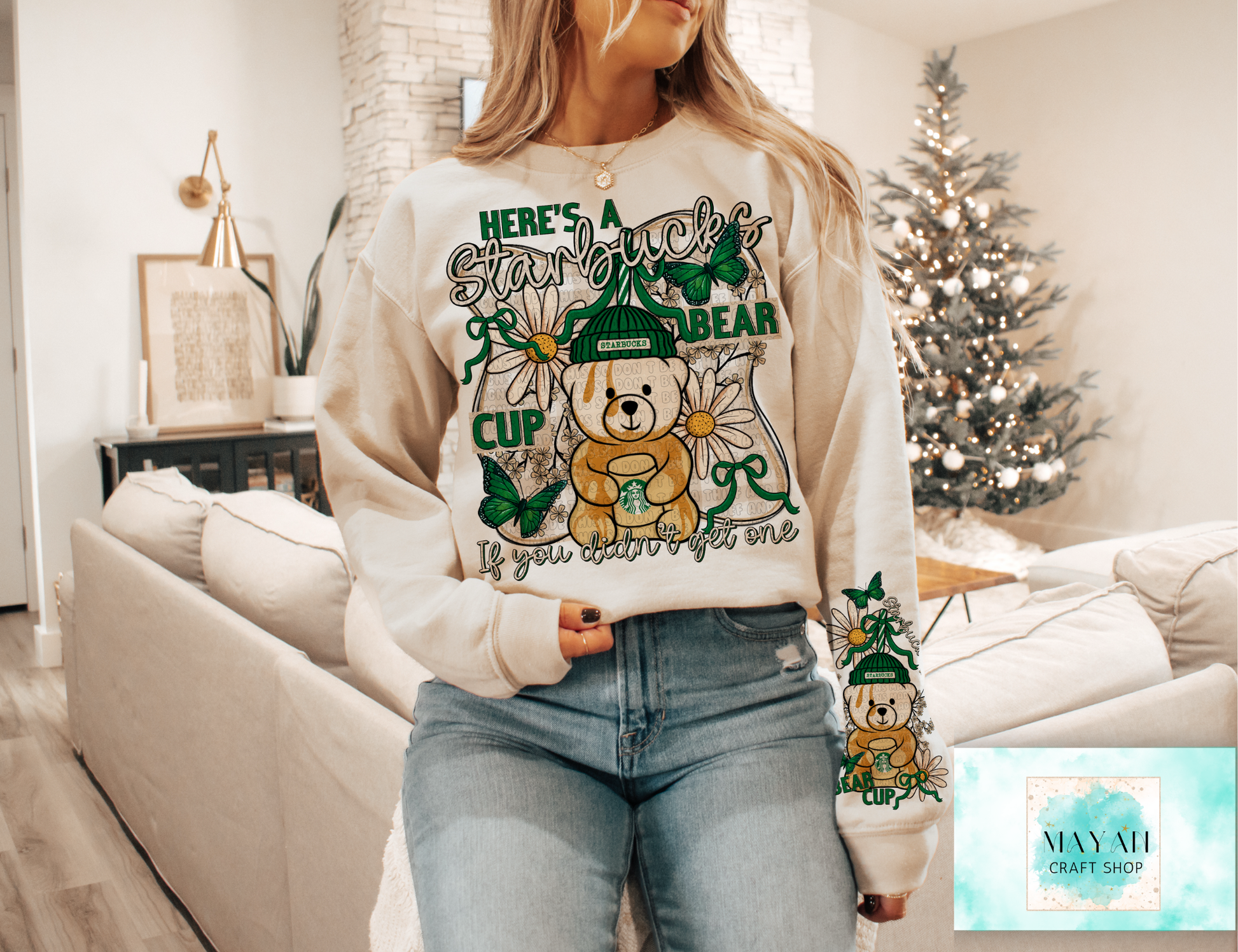 Person wearing a sweater with a bear graphic and text in a living room setting.