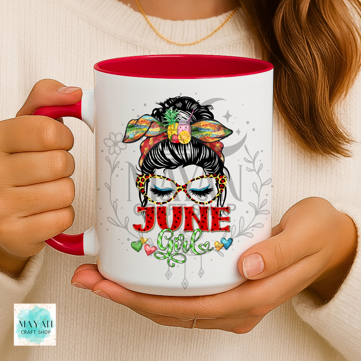 Person holding a mug with 'June Girl' design and colorful hair accessories.
