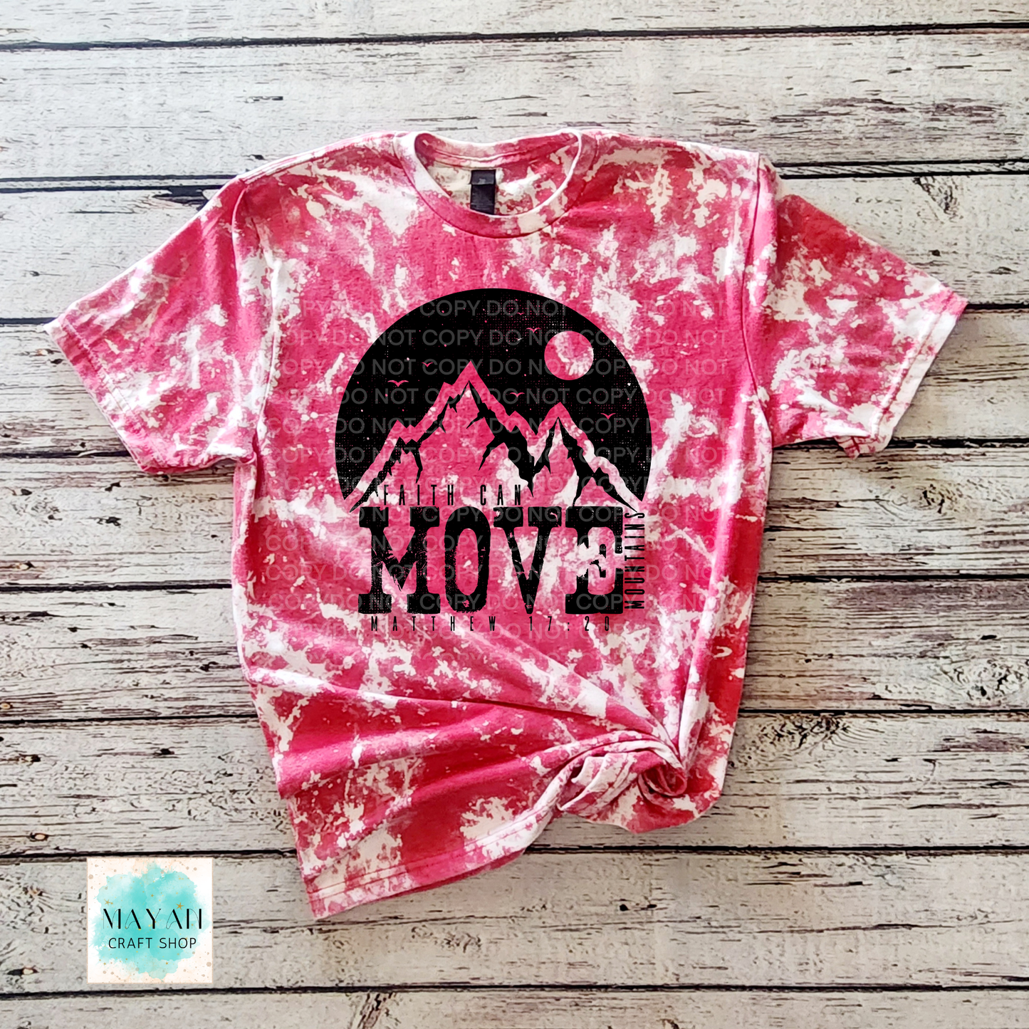 Pink tie-dye t-shirt with mountain graphic and 'MOVE' text on a wooden surface