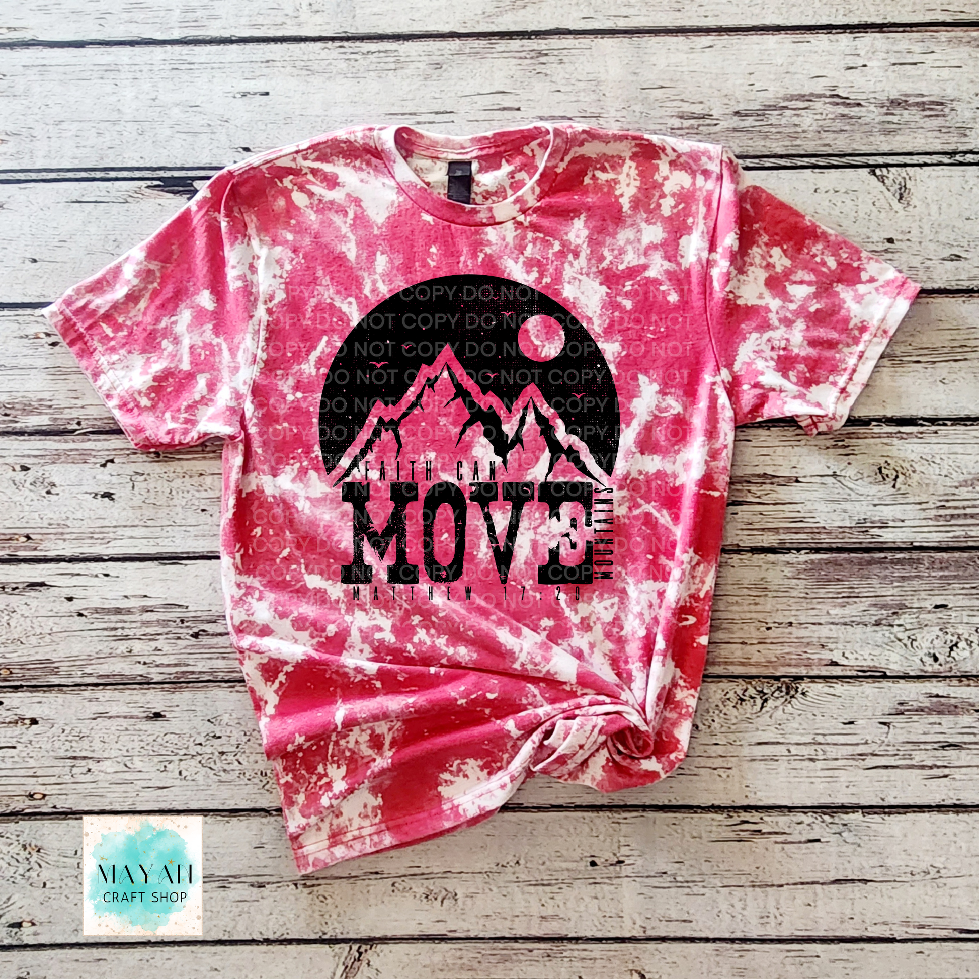 Pink tie-dye t-shirt with mountain graphic and 'MOVE' text on a wooden surface