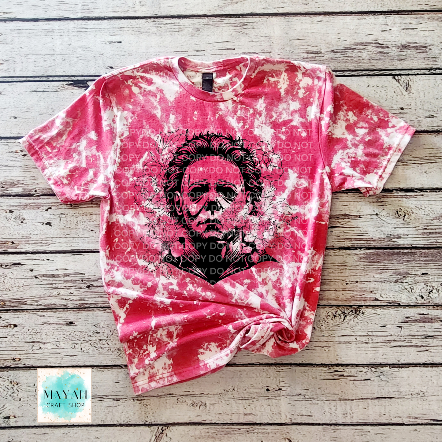 Red bleached t-shirt with a black graphic design on a wooden surface.