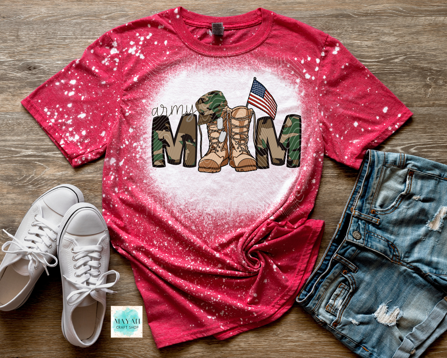 Red t-shirt with military mom design on a wooden surface with white sneakers and denim shorts.