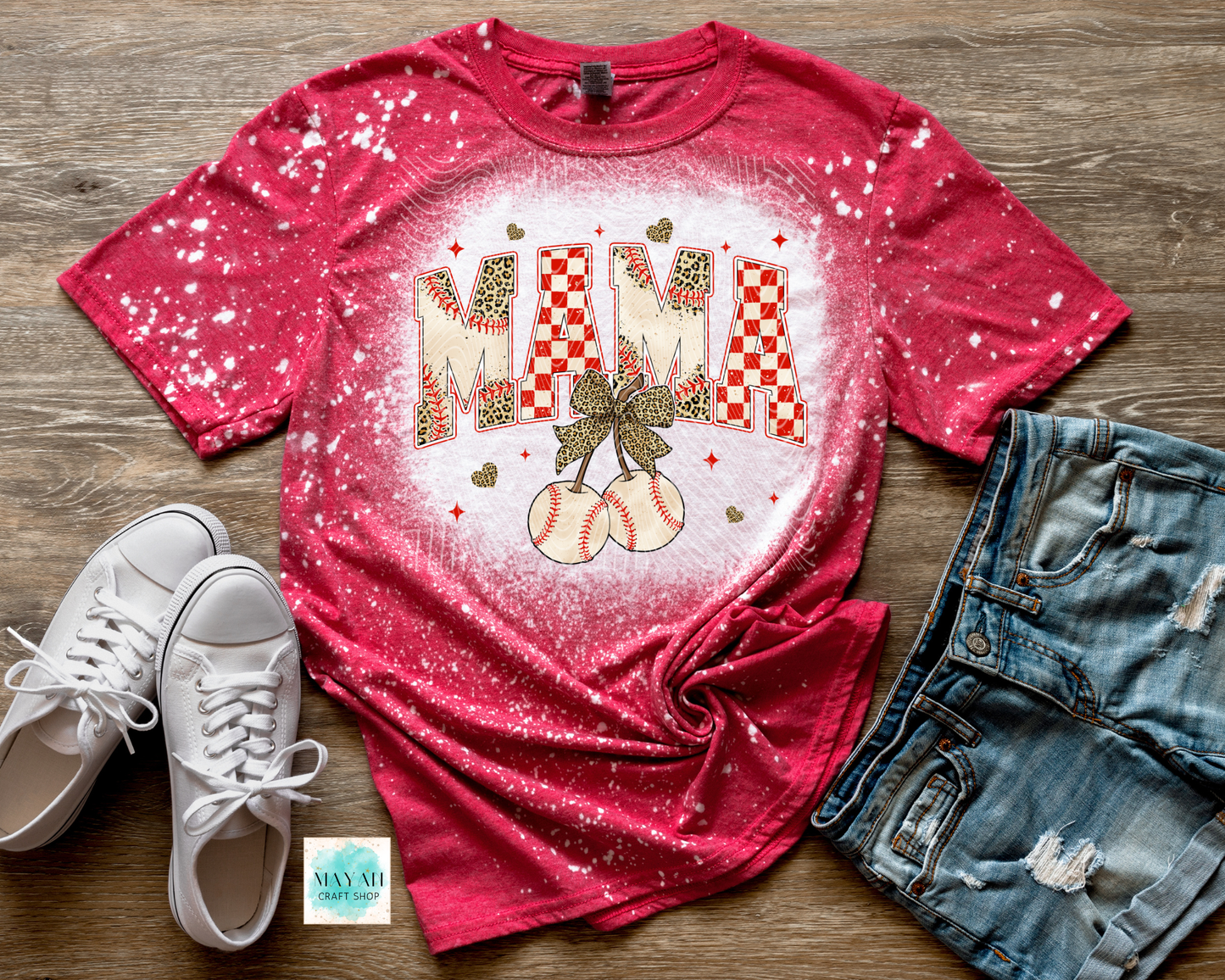Red t-shirt with 'MAMA' and pumpkin design on a wooden surface with white sneakers and denim shorts.