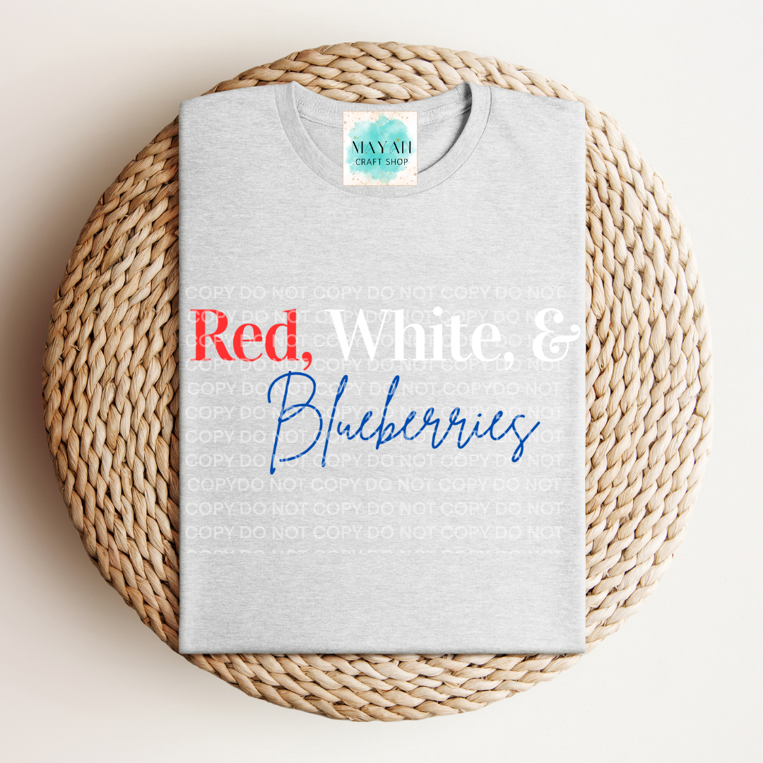 Gray t-shirt with 'Red, White & Blueberries' text on a woven mat