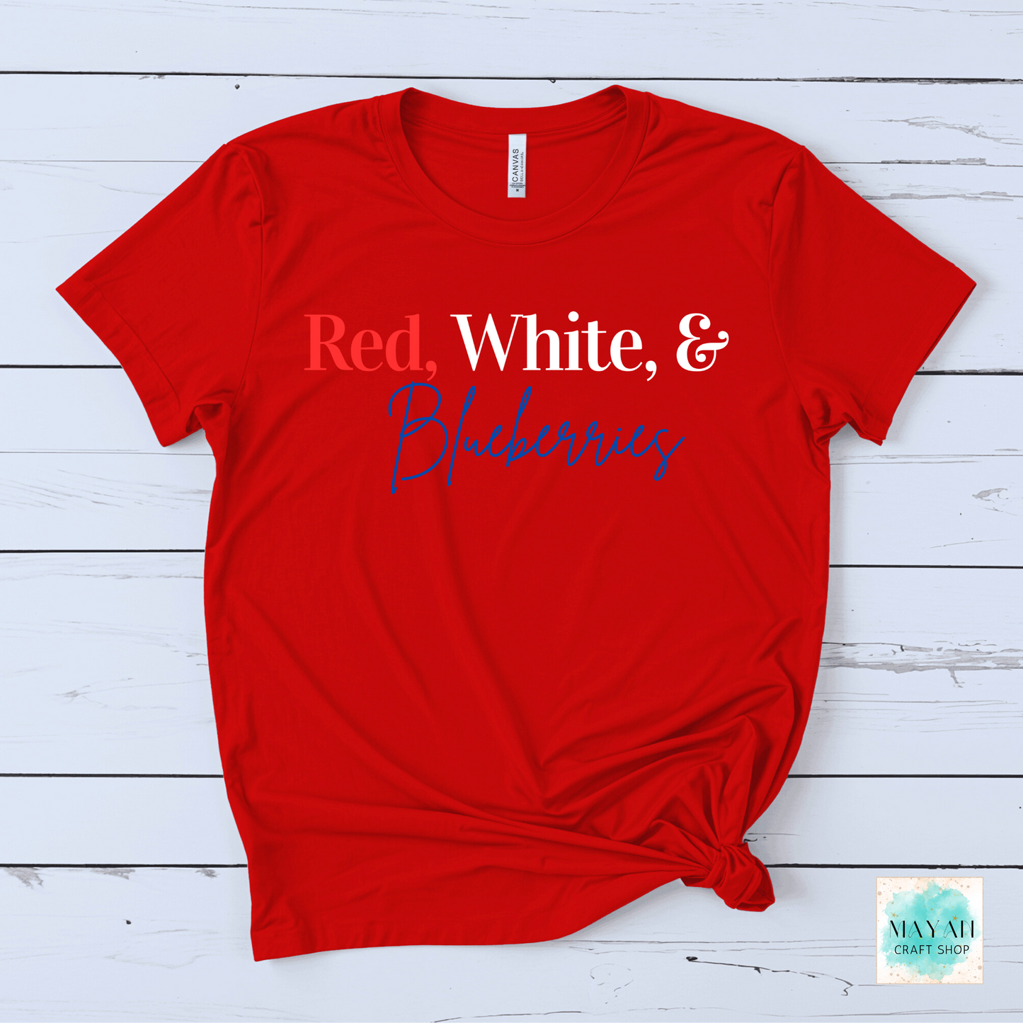 Red t-shirt with 'Red, White & Blueberries' text on a wooden surface