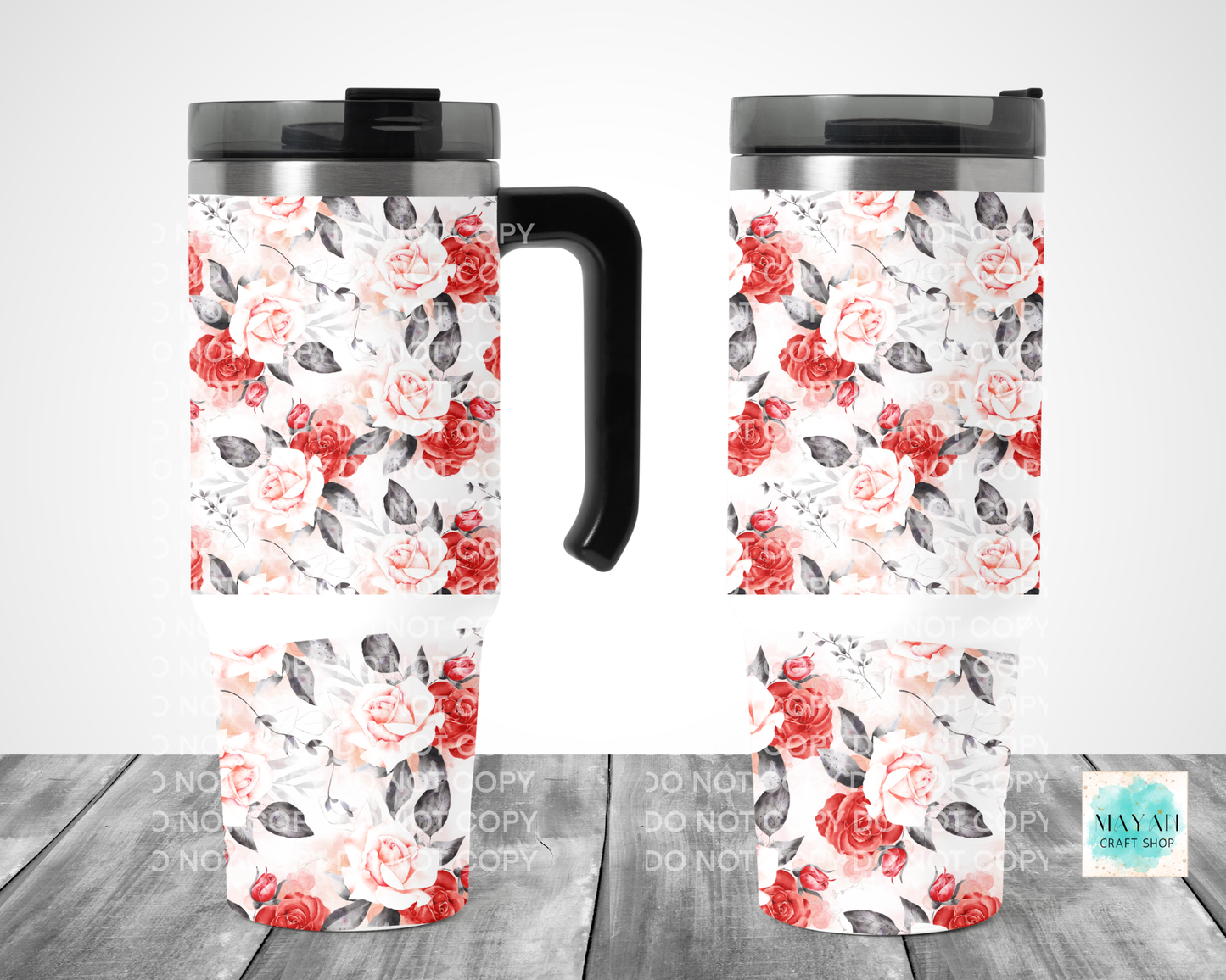 Two floral-patterned travel mugs on a wooden surface with a white background.