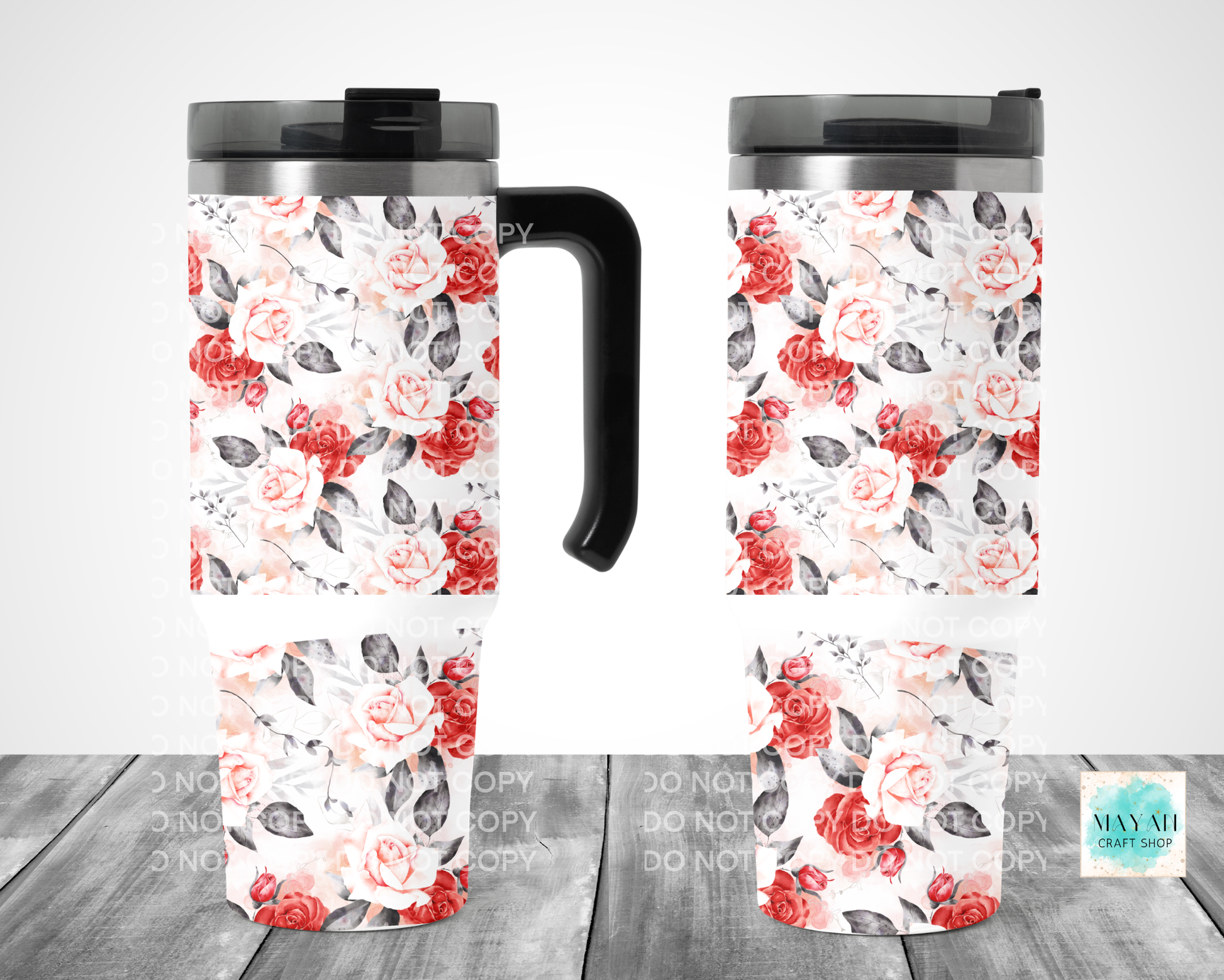Two floral-patterned travel mugs on a wooden surface with a white background.