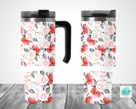 Two floral-patterned travel mugs on a wooden surface with a white background.