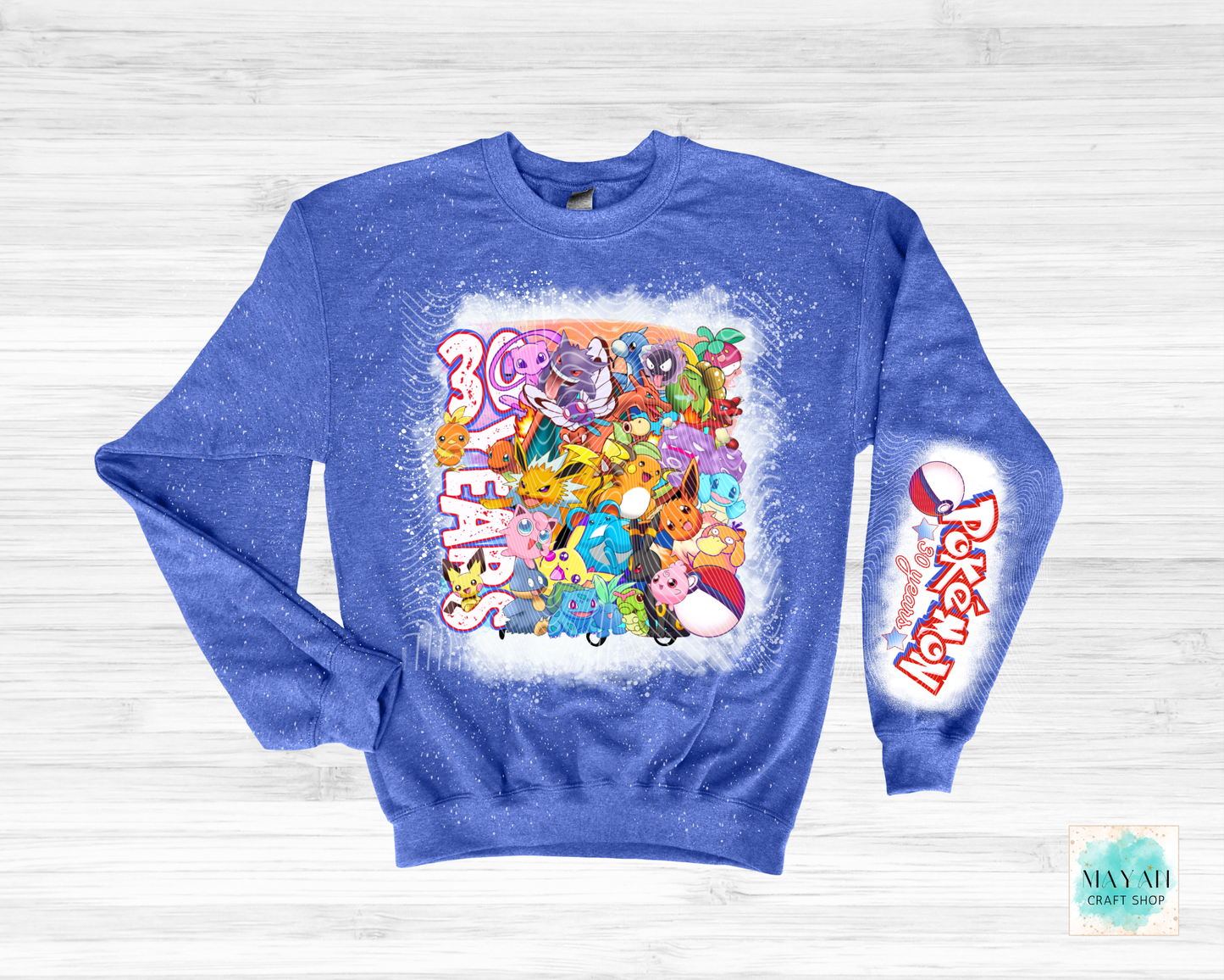 Blue sweatshirt with colorful graphic design on a light wooden background