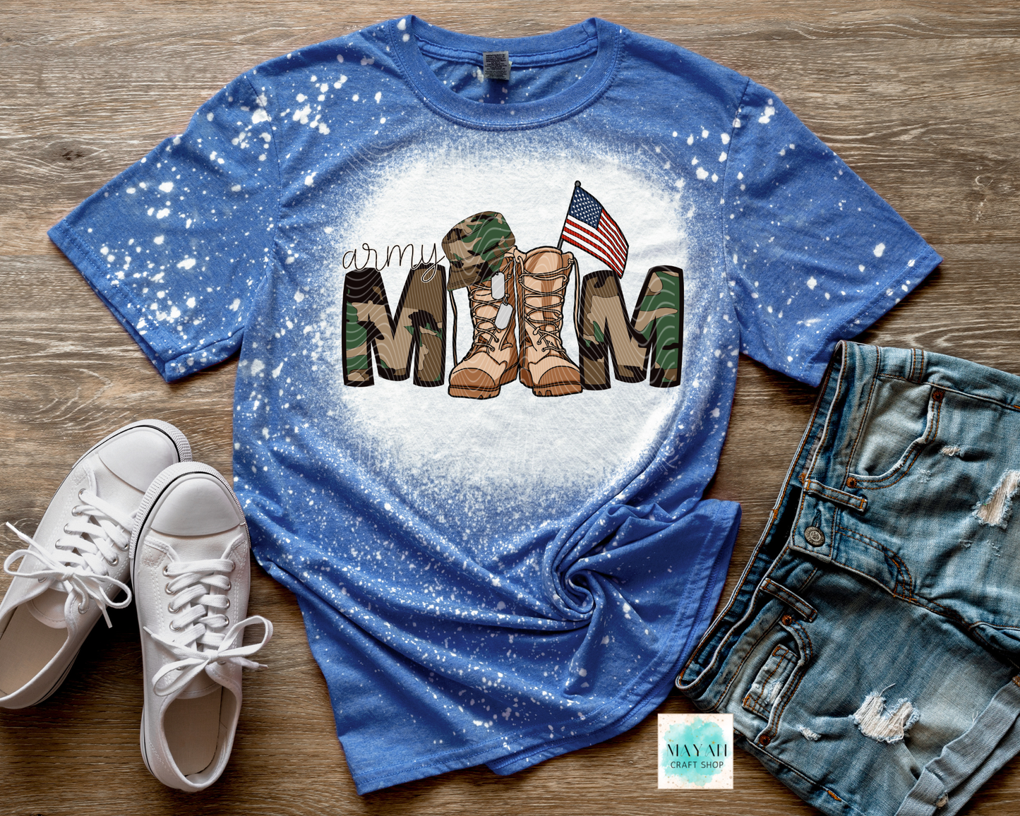 Blue t-shirt with military mom design on a wooden surface with shoes and jeans.