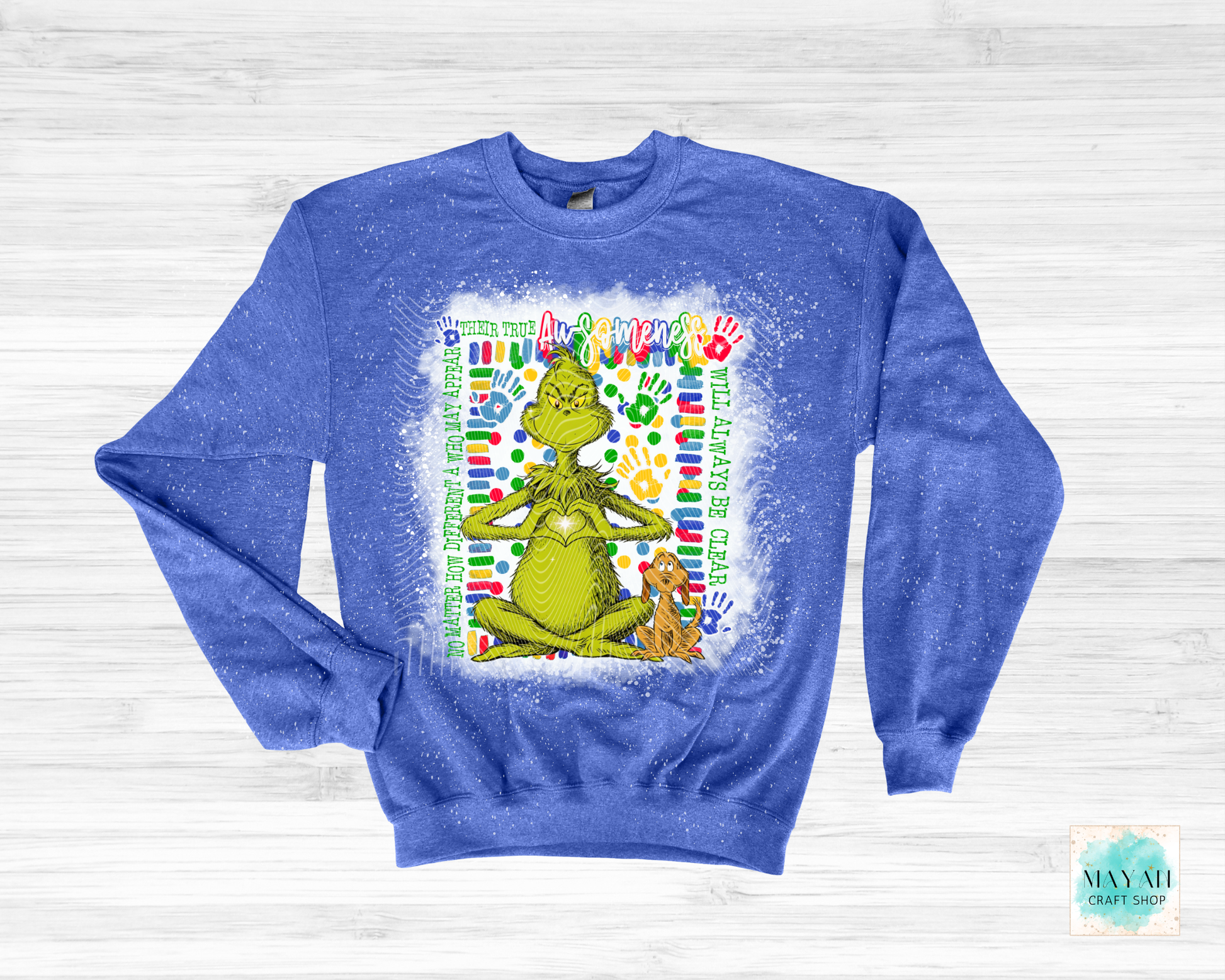 Blue sweatshirt with a graphic of a green character and a dog, on a light wooden background.