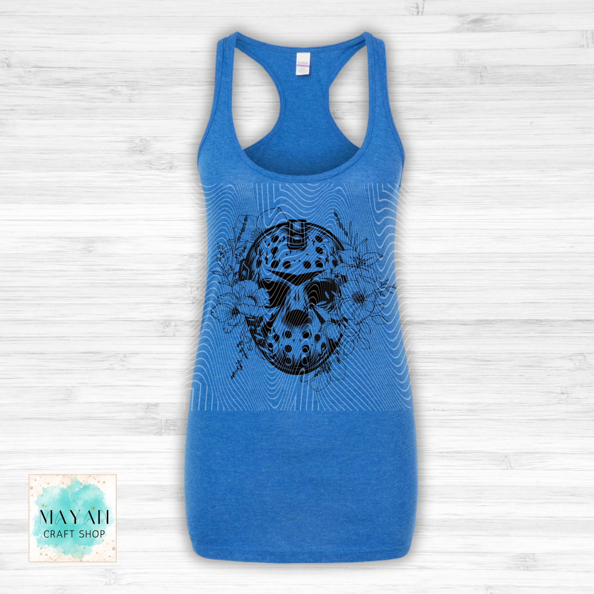 Blue tank top with a black graphic design on a light wooden surface.