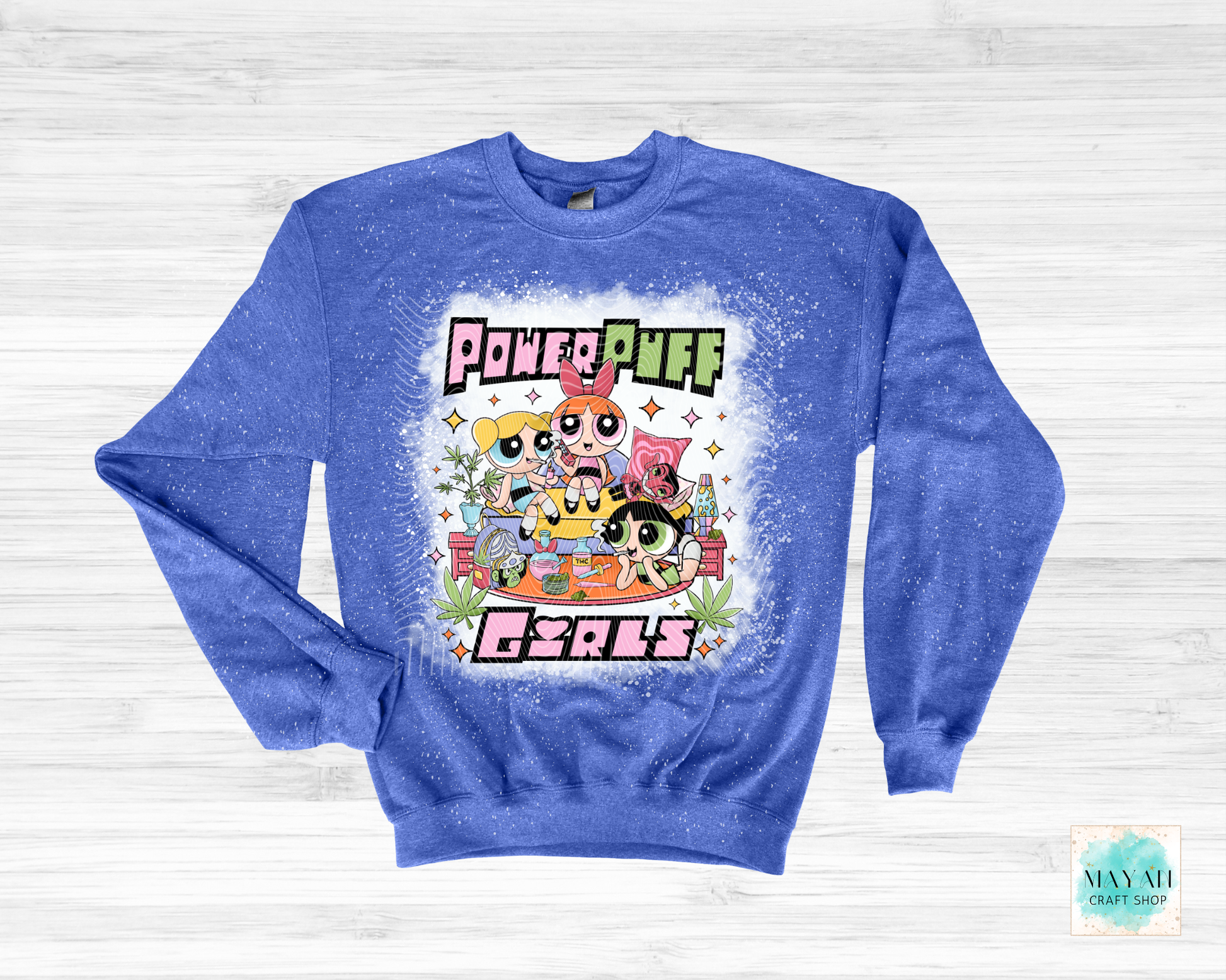 Blue sweatshirt with vibrant graphic on a white wooden background