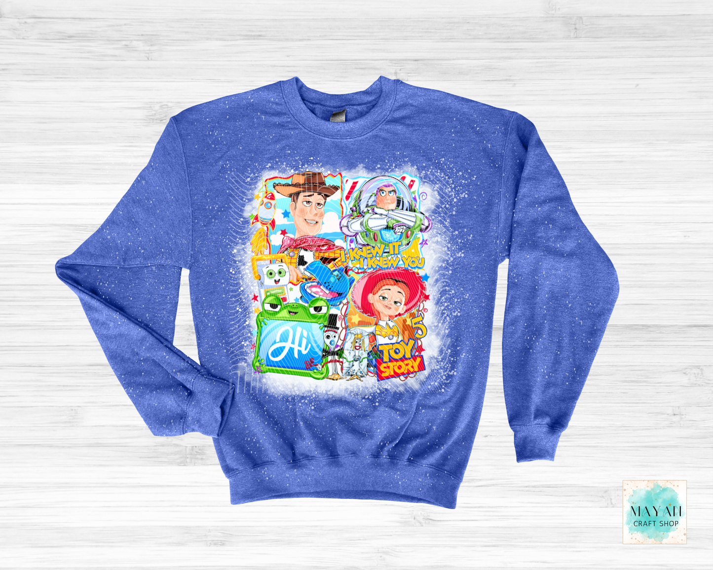Blue sweatshirt with character graphics on a white wooden background