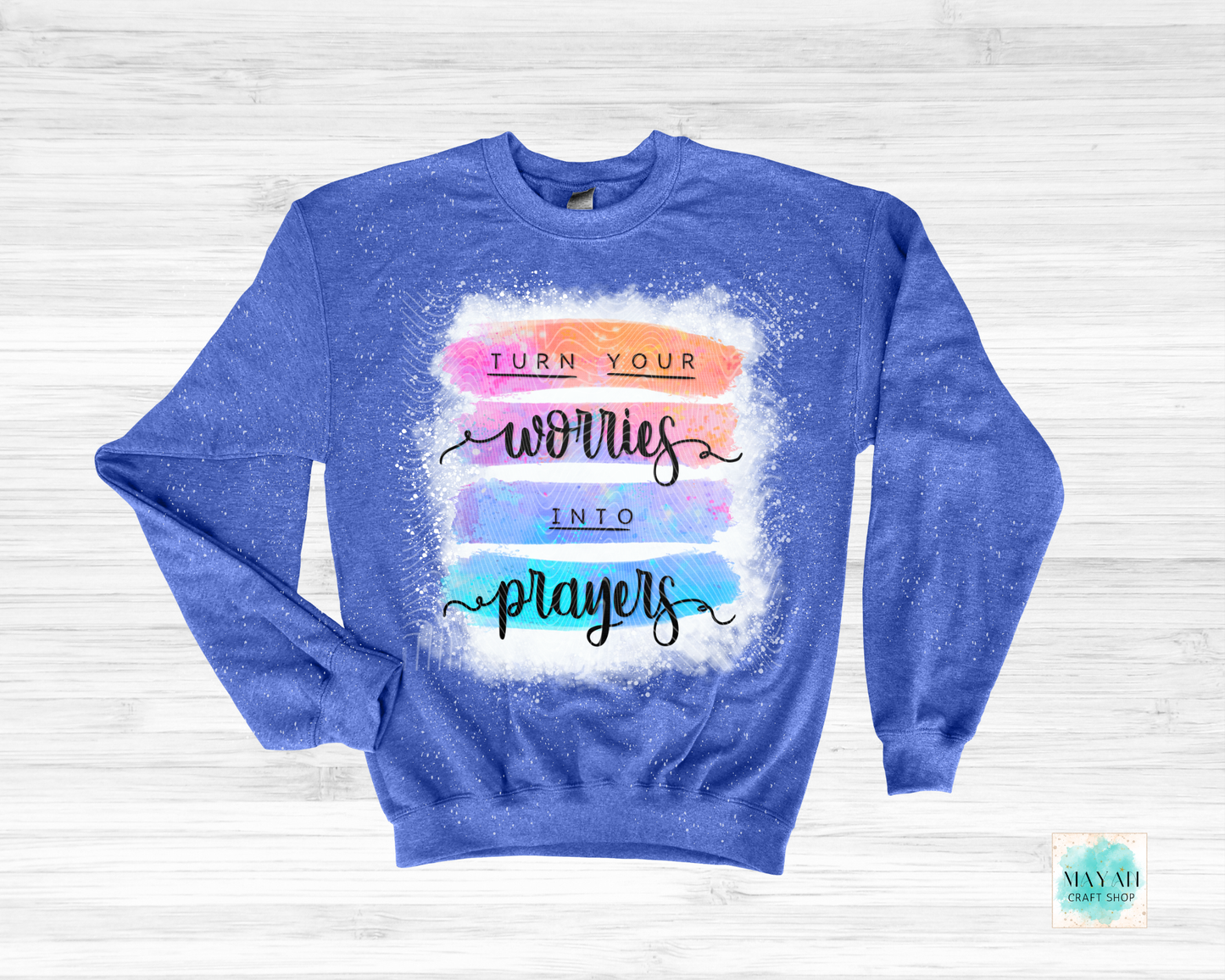 Blue sweatshirt with motivational quote on a light wooden background