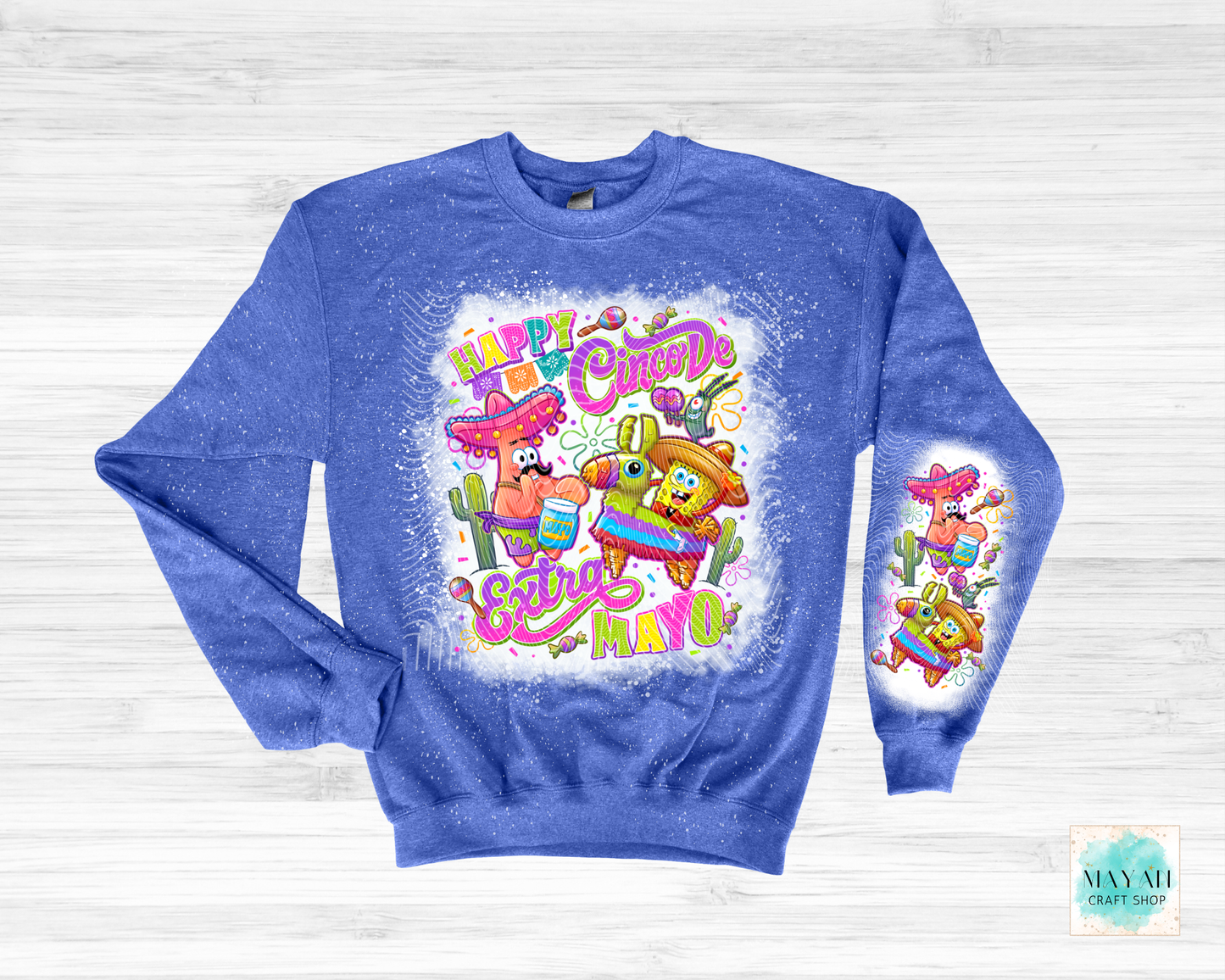 Blue sweatshirt with colorful 'Happy Cinco de Mayo' design on a light wooden background