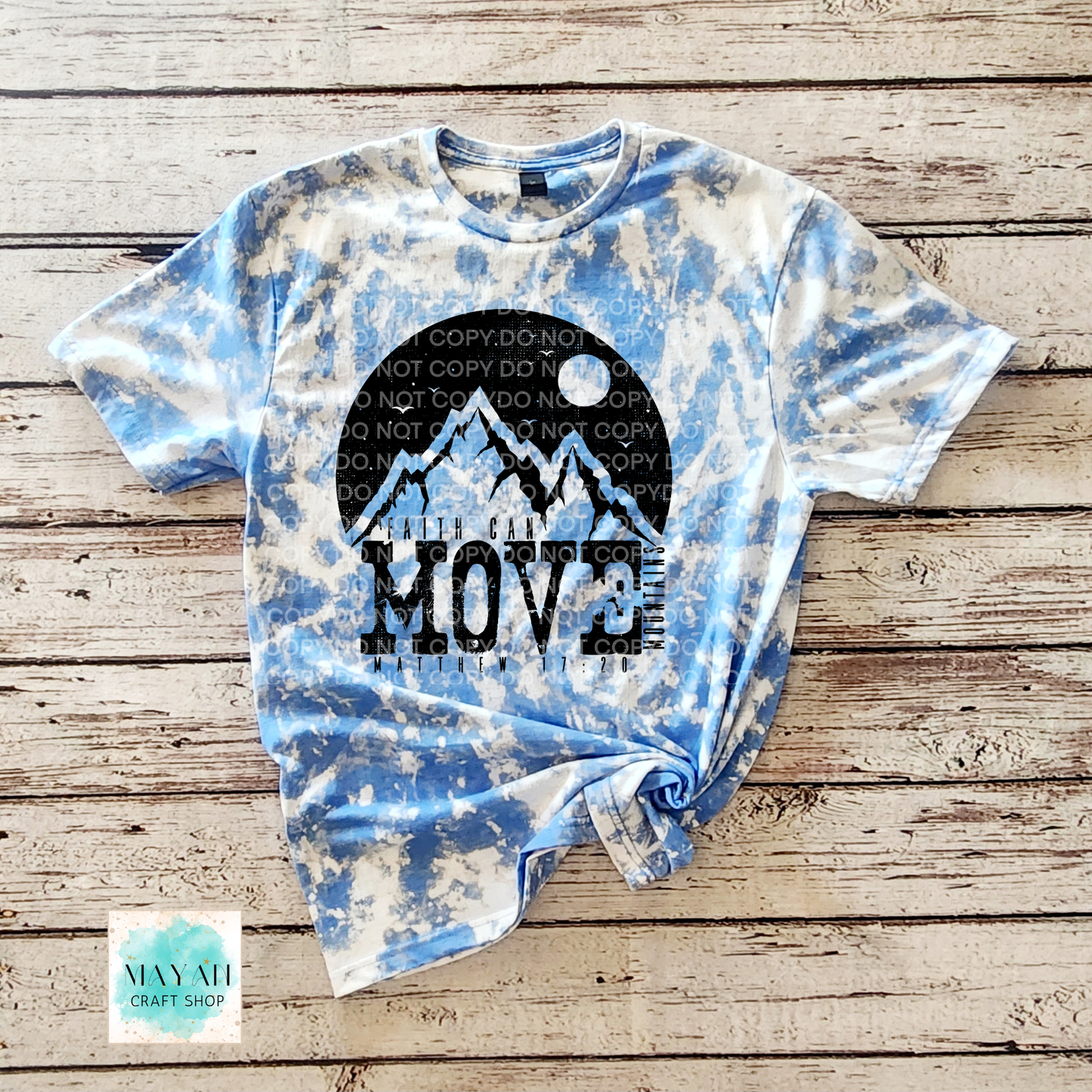 Tie-dye t-shirt with mountain graphic and 'Move' text on a wooden surface