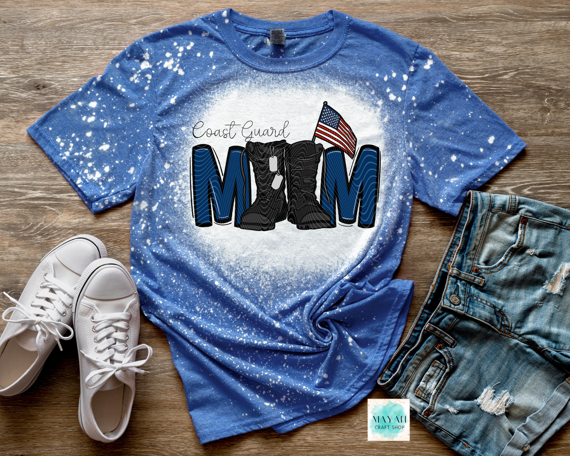 Blue t-shirt with military mom design on a wooden surface with shoes and jeans.