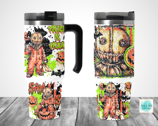 Two views of a travel tumbler mug with a Halloween-themed printed design featuring a scarecrow, and pumpkins.