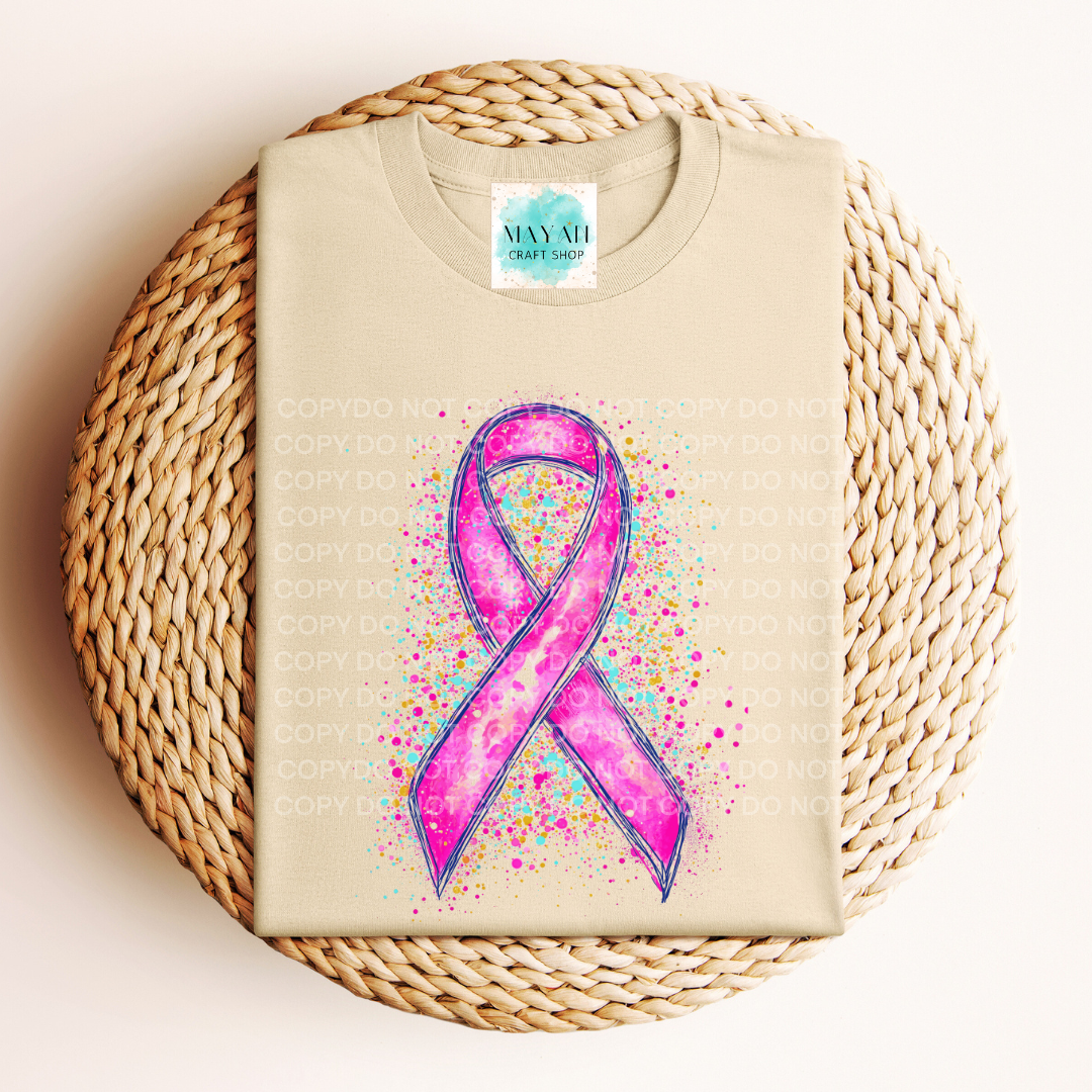 Beige t-shirt with a pink ribbon design on a woven surface