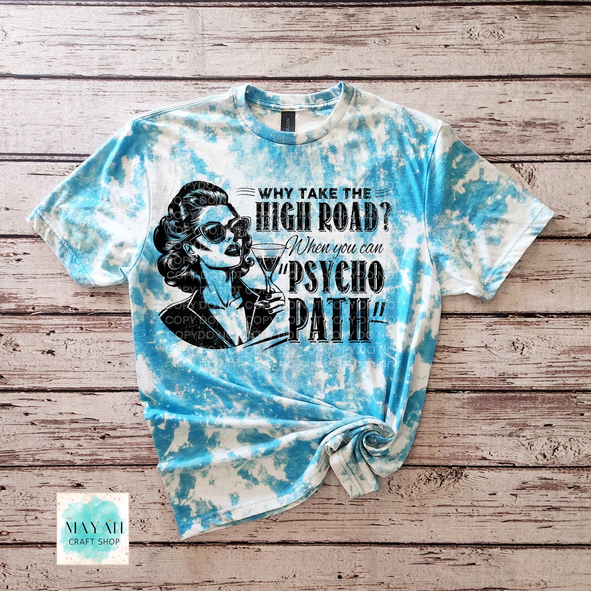 Tie-dye t-shirt with graphic design and text on a wooden surface
