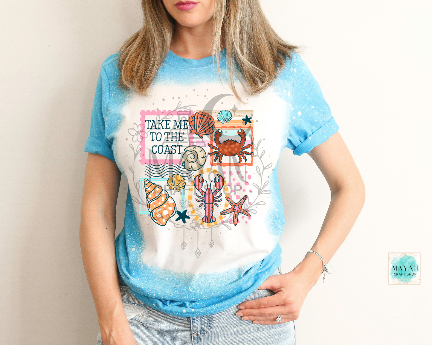 Person wearing a t-shirt with coastal design and text 'Take Me to the Coast'.