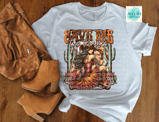 White t-shirt with graphic design and text, paired with brown jacket and boots on a wooden surface.