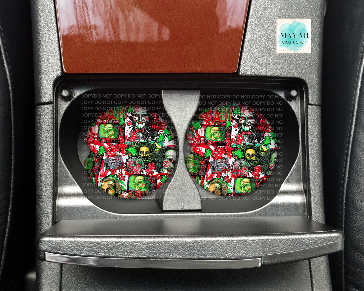 A pair of car cup holders installed in a center console, featuring a detailed graphic print of the character with a blood splatter background. The image is taken inside a vehicle.
