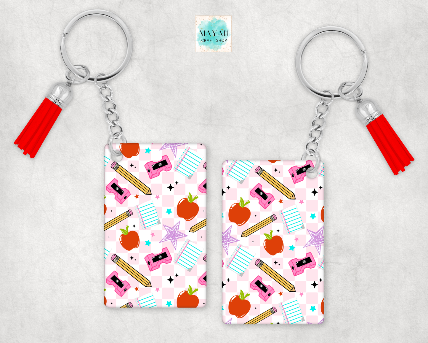 Two keychains with colorful patterns and tassels on a light gray background
