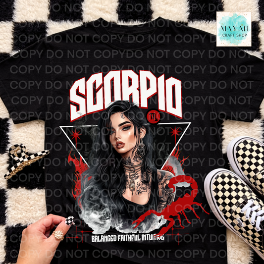 A black graphic t-shirt featuring a Scorpio-themed design with a woman's portrait, red and white text, and a red scorpion graphic, styled in a flat-lay with sneakers, a checkered wristband, and a hand on a black-and-white checkered rug.