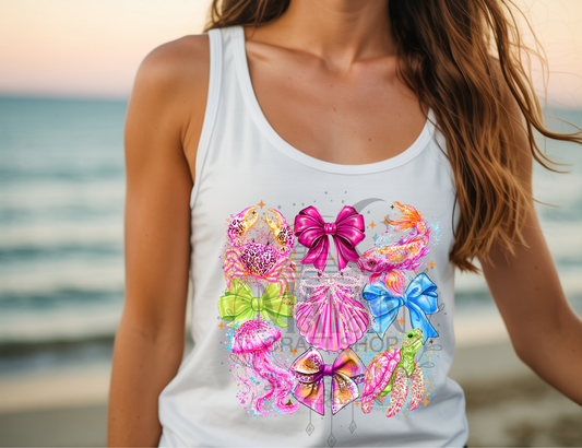 Person wearing a white tank top with colorful designs on a beach.