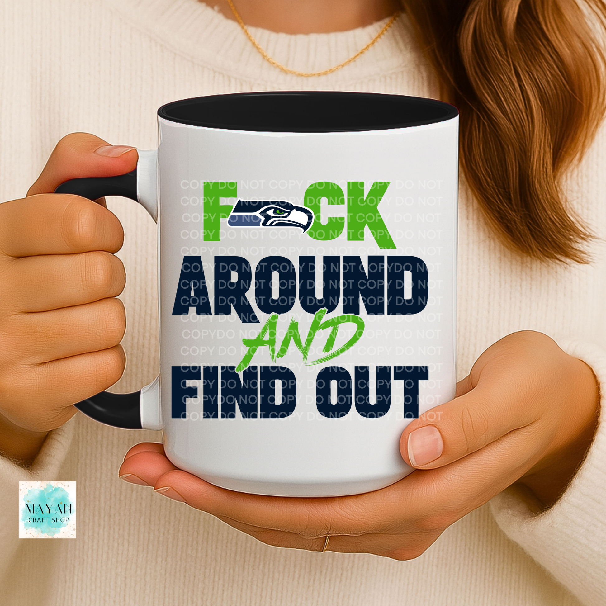 Person holding a mug with a design and text.