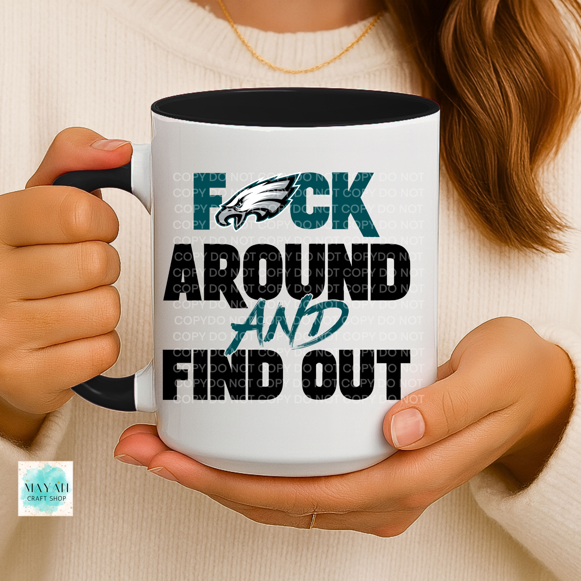 Person holding a mug with a graphic design and text.