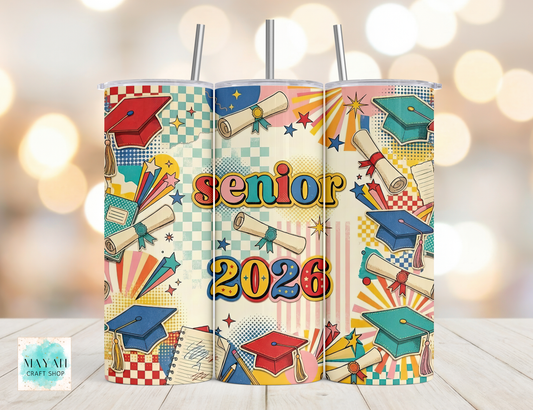 Three colorful tumblers with graduation-themed designs and 'senior 2026' text on a wooden surface.