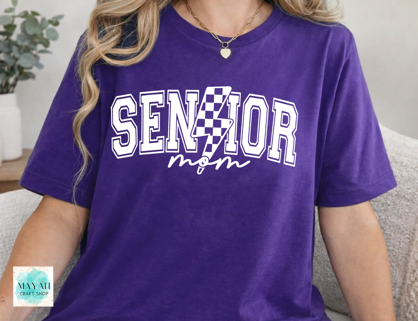 Person wearing a purple 'Senior Mom' t-shirt with a checkered design.