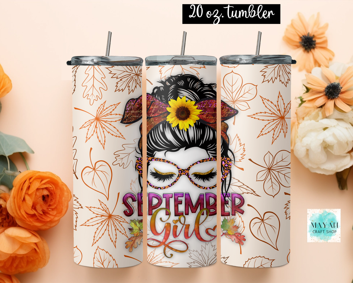 Three views of a 20 oz tumbler with a fall-themed 'September Girl' design, featuring a sunflower, glasses, and autumn leaves on a cream background, styled with flowers on a peach background.