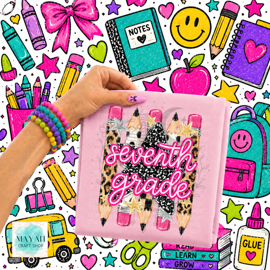A hand holds a pink shirt cover featuring three glittery pencils with leopard print and pink tips, overlaid with the words 'seventh grade' in pink glittery script. The background is a busy, colorful school-themed graphic pattern with crayons, notebooks, stars, and icons.