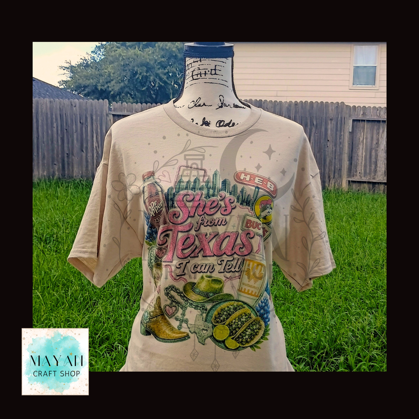 Beige t-shirt with Texas-themed graphics on a mannequin against a grassy background