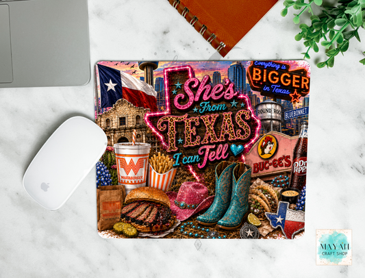 Colorful mouse pad with Texas-themed design on a marble surface.