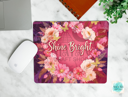 Floral mouse pad with 'Shine Bright' text on a marble surface