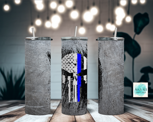Three cylindrical tumblers with unique designs on a wooden surface with blurred lights in the background.