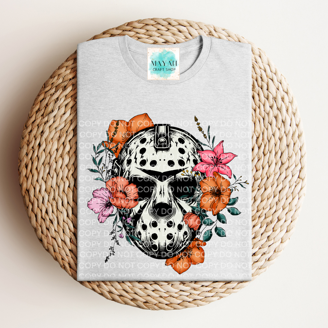 Gray t-shirt with a skull and floral design on a woven mat
